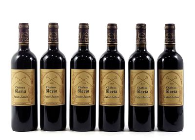 six bottles of wine are lined up on a white surface