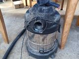un aspirateur posé par terre, sous une table