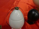 a white egg sitting on top of a table next to other items
