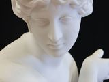 a white statue of a woman holding something in her hands