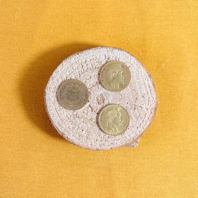 three coins sitting on top of a cake on a yellow surface
