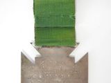 an image of a medal with a green ribbon on a white background