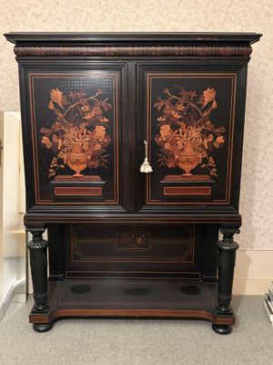 a black cabinet with flowers on it in a room