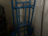 a blue gate in the corner of a room next to a pile of luggage
