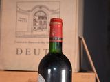 a bottle of wine sitting on a table next to a box of wine