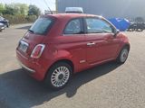 a small red car that is parked in a parking lot