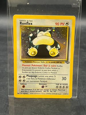 une carte Pokémon qui se trouve dans une boîte transparente