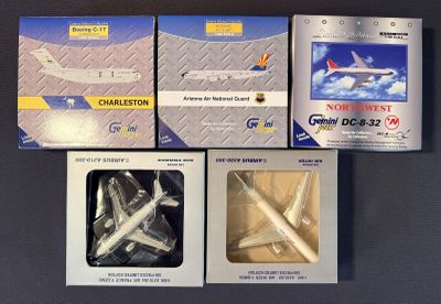 quatre boîtes contenant différents types d'avions, posées sur une table