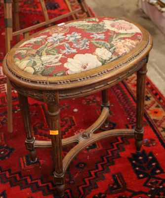a small wooden stool with a floral seat on a red rug