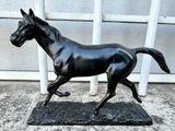 a statue of a horse running on a black base