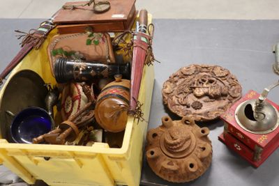 une boîte jaune remplie d'objets divers, posée sur une table