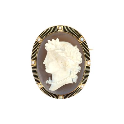 Une broche représente le visage d'une femme.
