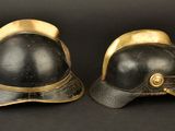 pair of black and gold fire helmets on a black background