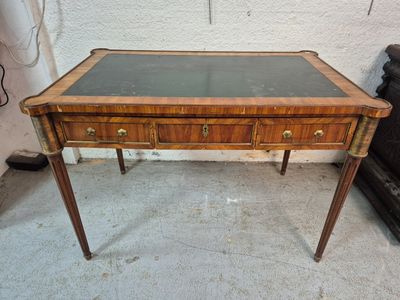 a small desk with a glass top on a cement floor