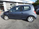 a small blue car parked in front of a building