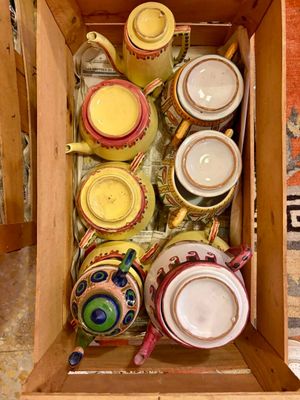une boîte en bois remplie de différentes sortes de théières