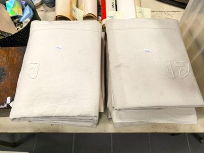 two sheets of white cloth on a table next to a pair of scissors