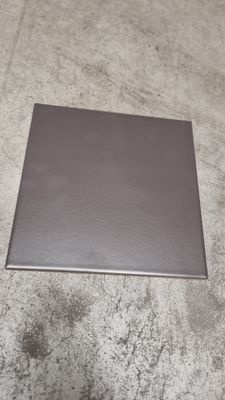 grey square tile on the floor with a white wall in the background