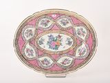 une assiette rose et dorée ornée d'un motif floral