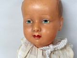 a small doll that is sitting on a white surface