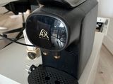 a black coffee machine sitting on top of a white box