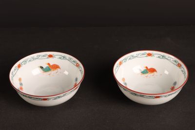 pair of chinese bowls with floral designs on them on a black surface