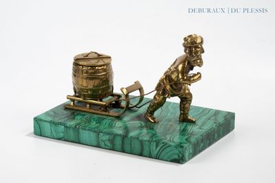 brass figurine of a man pulling a barrel on a plow