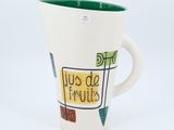 a coffee cup that has a green handle on it
