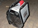 un petit ventilateur posé par terre à côté d'un support métallique