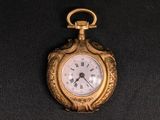 a gold pocket watch with roman numerals on it