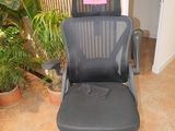 a black office chair with a pink sticker on it