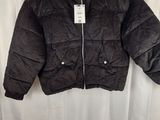 the jacket is black and has a white tag on it