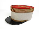 un chapeau blanc bordé de rouge, surmonté d'un chapeau noir