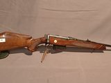 un fusil avec un canon en bois sur fond blanc