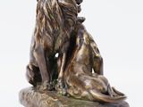 bronze statue of a lion and a lioness sitting on a rock