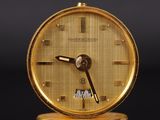 a gold clock that is sitting on a table