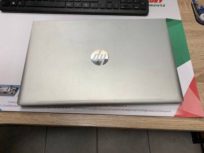 un ordinateur portable posé sur un bureau, avec un clavier et une souris