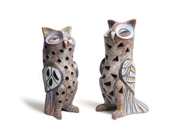 two owl figurines sitting next to each other on a white surface