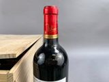 a bottle of wine sitting on a table next to a wooden box