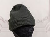 a black mannequin head with a green hat on it