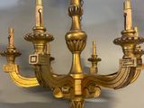 a gold colored chandelier with five candles on it
