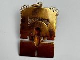 a gold plated pendant with a picture on it