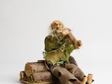 a figurine of an old man sitting on a pile of books