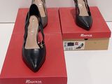une paire de chaussures à talons hauts noires et marron posées sur une boîte rouge