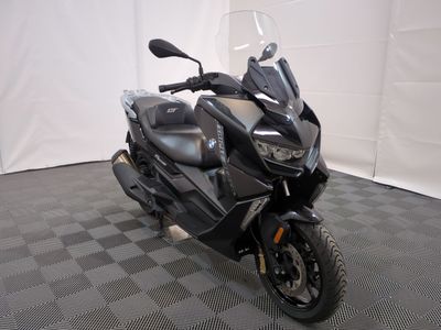 une photo d'une moto noire garée sur un sol à damier