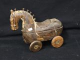 a wooden toy horse that is sitting on a black background