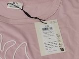 a pink t - shirt with a white design on it