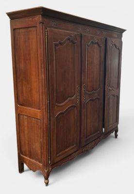 une photo d'une grande armoire en bois comportant deux portes d'un côté et deux tiroirs de l'autre