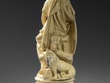 a carved statue of a man with a dog on a pedestal
