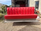 a red couch that is in the back of a truck